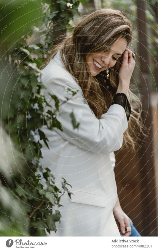 Frau sitzt auf Pflanzer im Garten Pflanzen Sitzen Jeansstoff Stil Hinterhof Straße grün Flora trendy aufgeregt Freude Glück Lifestyle Freizeit organisch