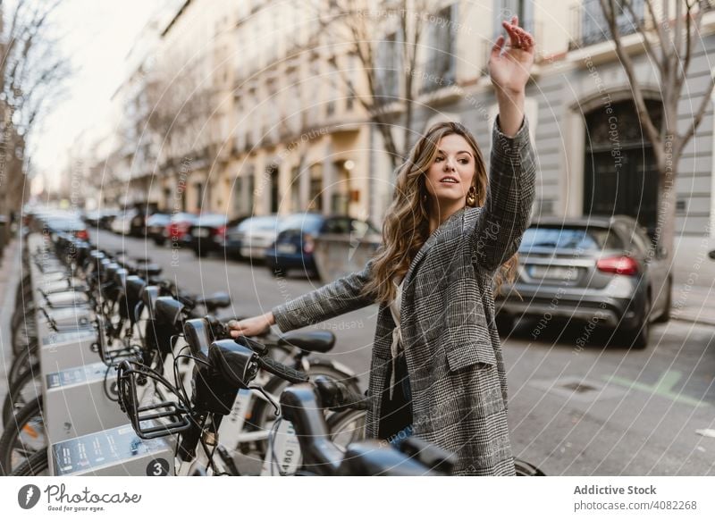 Dame wählt Mietfahrrad auf Parkplatz Öffentlich elegant Fahrrad Wochenende Freizeit Straße Freude Miete im Freien Reise Ausflug Frau Lifestyle Verkehr Urlaub