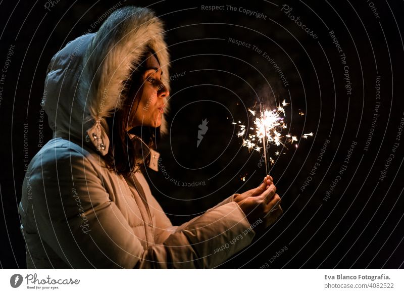 schöne junge Frau, die in der Nacht funkelt, Spaß hat und lächelt Party Licht dunkel Feuer Feuerwerk Hand Flamme Funkelt hell Lebensstile Hintergrund Glück