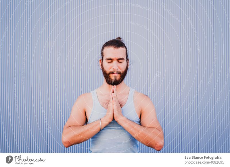 mann in der stadt, der yoga-sport betreibt. blauer hintergrund. gesunde lebensweise Blauer Hintergrund Yoga Mann Großstadt urban Lifestyle muskulös