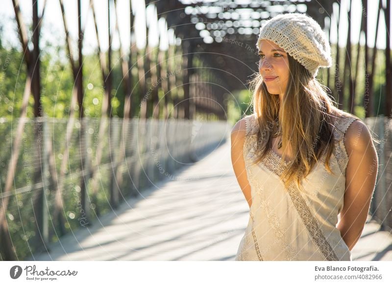 Porträt einer jungen Frau bei Sonnenuntergang im Freien Glück blond Hut blaue Augen Brücke Sommer sonnig Behaarung Fröhlichkeit Lifestyle Gesicht schön Spaß