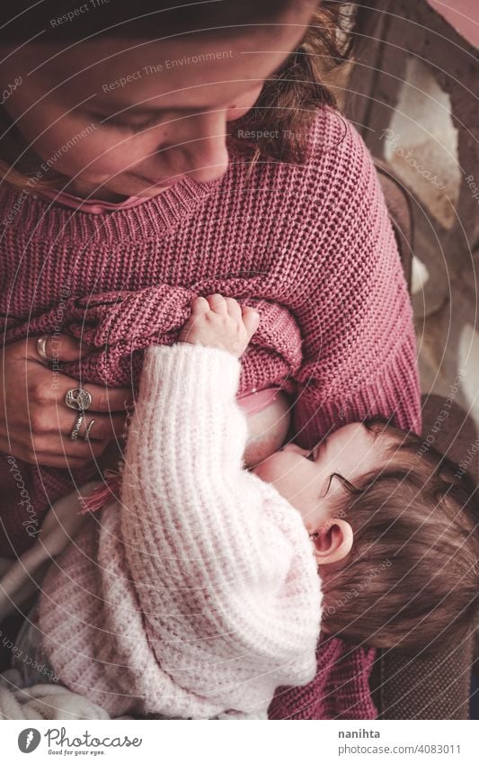 Junge Frau, die ihr Baby stillt Stillen Mama Mutterschaft Familie Exklusivität Kindheit neugeboren rosa warm gemütlich natürlich wirklich Leben realistisch