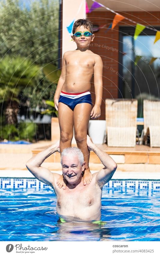 Großvater trägt seinen Enkel auf den Schultern in einem Schwimmbad Hinterhof Gleichgewicht blau Junge sorgenfrei Kaukasier Kind Kindheit Kinder kühlen Hof