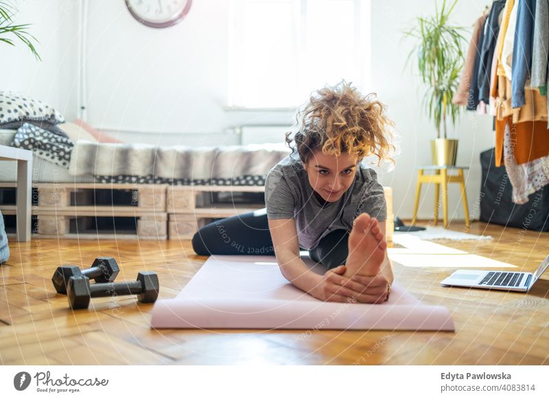 Junge Frau macht Fitness-Übung zu Hause Gerät Training Trainingsmatte Fitnessstudio passen Spaß Sport Gesundheit Stock Yoga aktiv Glück Lächeln heiter