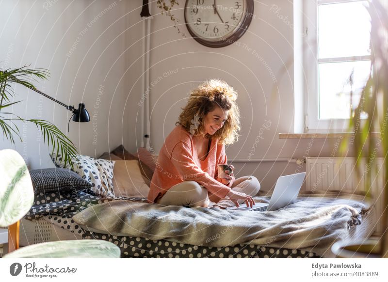 Junge Frau arbeitet im Bett zu Hause mit Laptop Bildung Lernen studierend Hausaufgabe Buch E-Learning Technik & Technologie Computer arbeiten Internet online