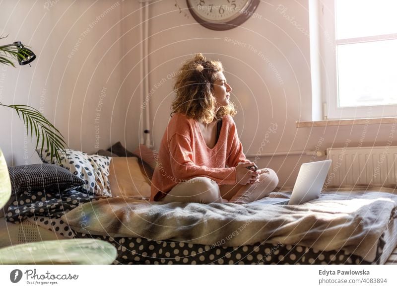 Junge Frau arbeitet im Bett zu Hause mit Laptop Bildung Lernen studierend Hausaufgabe Buch E-Learning Technik & Technologie Computer arbeiten Internet online