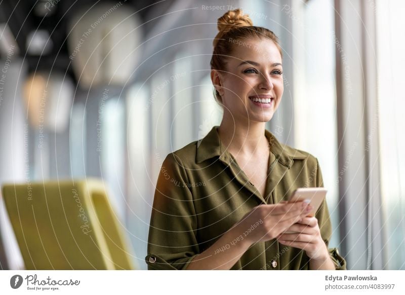 Junge Geschäftsfrau mit Mobiltelefon in ihrem Büro Frau Mädchen Menschen Unternehmer Business gelungen Erfolg professionell jung Erwachsener Lifestyle