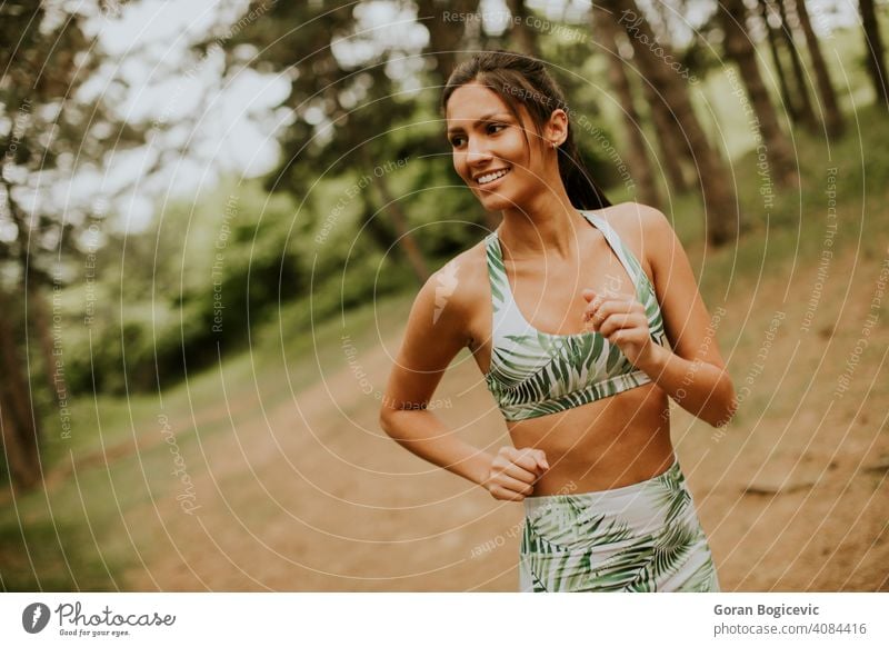 Junge Fitness-Frau läuft auf Waldweg Athlet Park aktiv grün Übung laufen jung im Freien Läufer Joggen Training Jogger passen Baum Lifestyle Sport ländlich