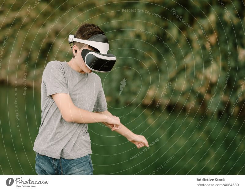 Junger Teenager mit Virtual-Reality-Brille im Freien virtuell Realität VR Jugendlicher Natur Headset Technik & Technologie Spiel futuristisch 3d jung modern