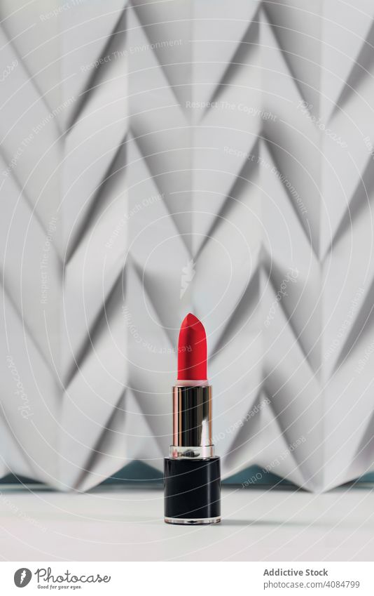 Rosa Lippenstift auf erhöhtem weißen Chevron. Produkt und Make-up zeitgenössisches Konzept rosa rot farbenfroh Stillleben Glamour Frau Hintergrund Kosmetik