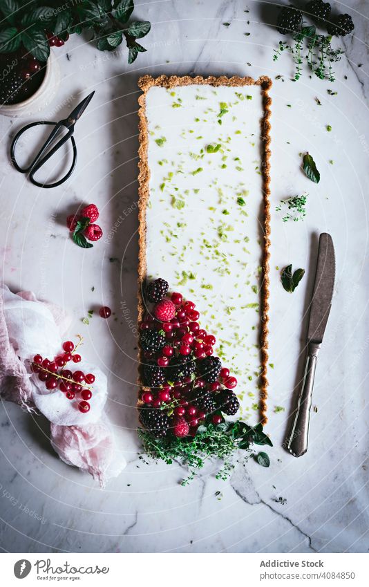 Limettenkuchen mit Beeren dekorierend Kuchen Dessert Lebensmittel süß geschmackvoll selbstgemacht lecker Tischplatte Himbeeren Stil kulinarisch Stillleben