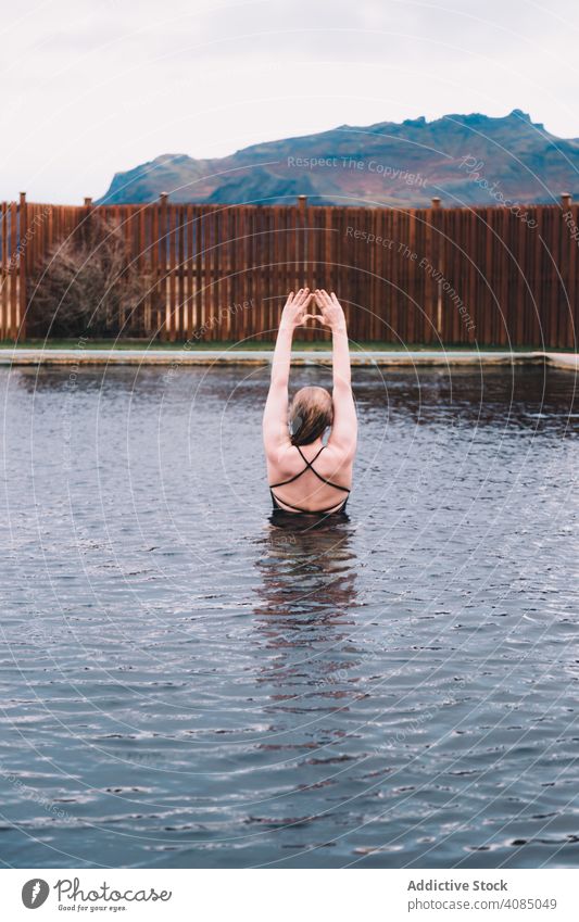 Frau im Pool in der Nähe von Meer und Hügeln am Ufer MEER Klippe jung Hand Seite Wasser aussruhen Küste Felsen Himmel stürmisch wolkig Sommer Erholung