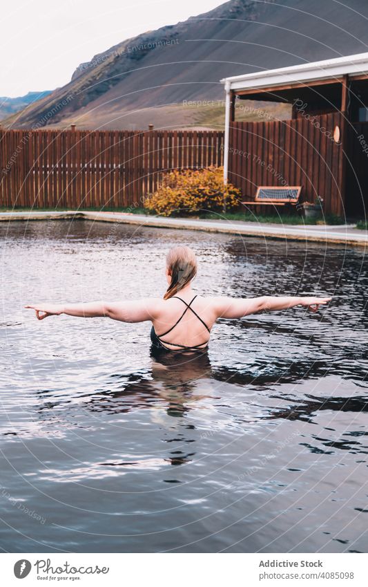 Frau im Pool in der Nähe von Meer und Hügeln am Ufer MEER Klippe jung Hand Seite Wasser aussruhen Küste Felsen Himmel stürmisch wolkig Sommer Erholung