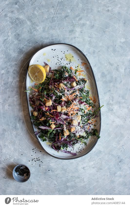 Mohn-Zitronen-Nahkostsalat mit Croutons und Parmesan Salatbeilage Gemüse Saatgut Speise Teller Tisch Löffel serviert Portion Gesundheit Lebensmittel Käse