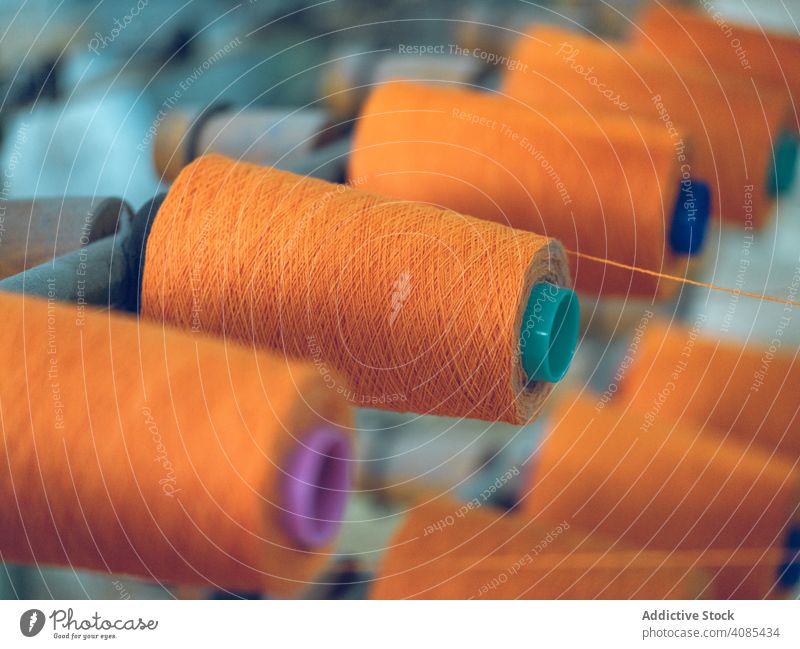 Fadenspulen auf Webstuhl Faser Spulen Industrie Fabrik Sehne Baumwolle Textil Gewebe Maschine Herstellung Schnur Handwerk Garn Stoff orange hell Farbe Material