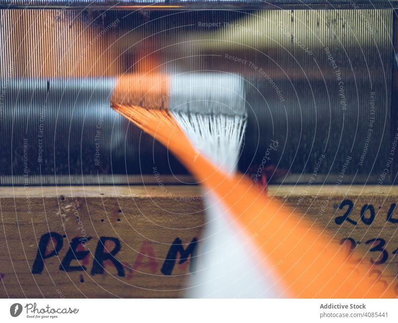 Weiße und orangefarbene Fäden auf dem Webstuhl Faser Industrie Baumwolle Textil Weberei Sehne Stoff Fabrik Gewebe Schnur Material Maschine Handwerk traditionell