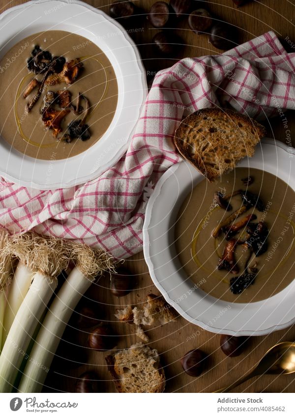 Brot und Schalotten bei Kastaniensuppe Suppe Sahne Frühlingszwiebel Lebensmittel Serviette Tisch Küche rustikal Schüsseln Abendessen Mittagessen Feinschmecker