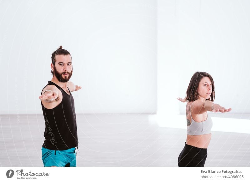 junger Mann und Frau üben Yoga-Sport in der Turnhalle. Gesunder Lebensstil Junge Gesundheit Lifestyle im Innenbereich Fitnessstudio Atelier weiß hispanisch