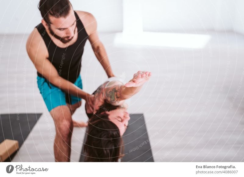 junger Mann und Frau üben Yoga-Sport in der Turnhalle. Gesunder Lebensstil Junge Gesundheit Lifestyle im Innenbereich Fitnessstudio Atelier weiß hispanisch