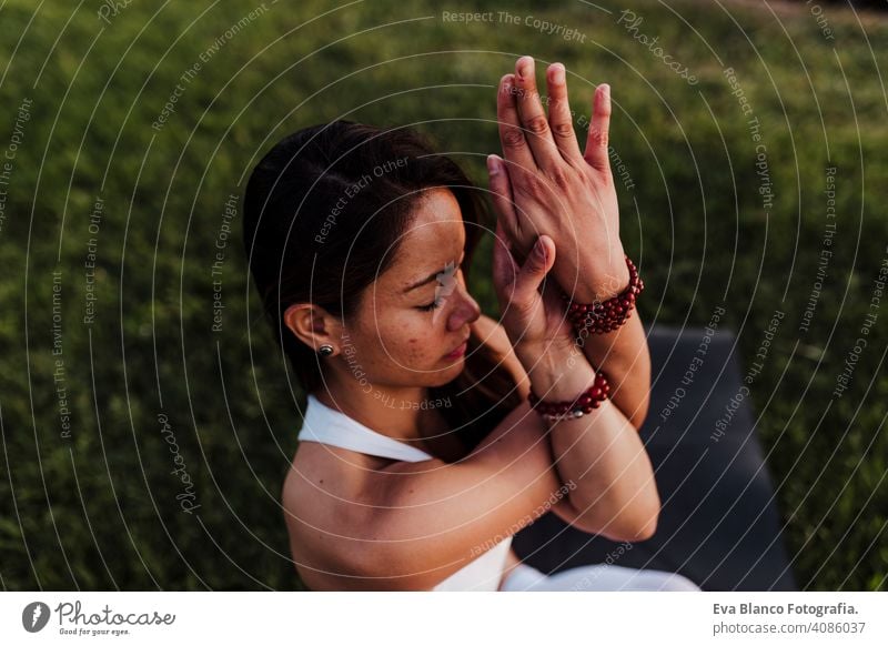 junge schöne asiatische Frau macht Yoga in einem Park bei Sonnenuntergang. Yoga und gesunden Lebensstil Konzept. Sommer Glück Genuss Sport Lifestyle sportlich