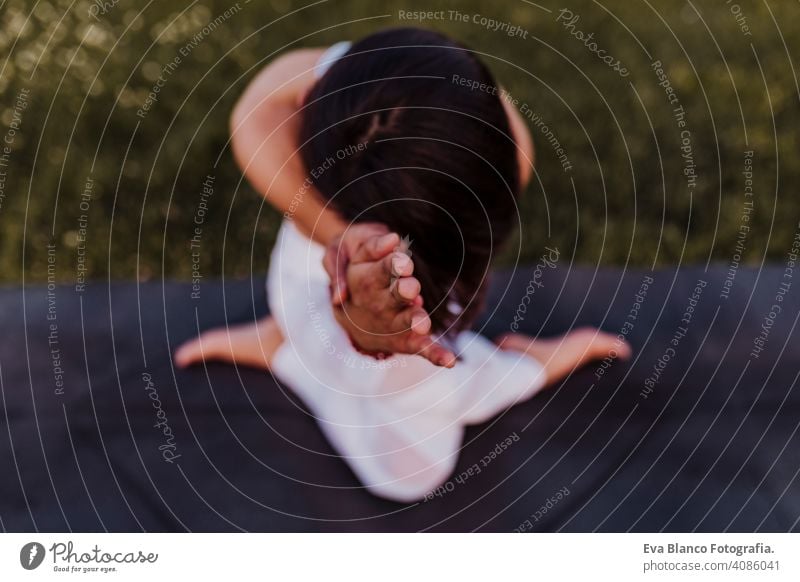 junge schöne asiatische Frau macht Yoga in einem Park bei Sonnenuntergang. Yoga und gesunder Lebensstil Konzept. Ansicht von oben. Selektiver Fokus Sommer Glück