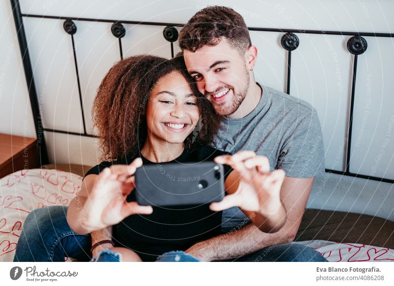 glückliches Paar in der Liebe zu Hause. Afroamerikanische Frau und kaukasischen Mann ein Selfie mit Handy nehmen. ethnische Liebe Konzept Afroamerikaner