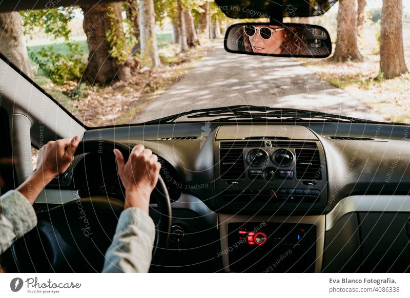 Junge schöne Frau fährt ein Auto. Reise-Konzept. Blick von innen. Weg der Bäume Straße jung fahren PKW sonnig Sonnenbrille reisen reisend Rad Laufwerk mieten