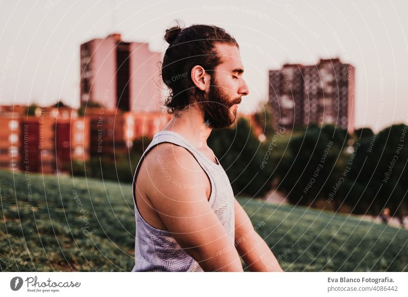 junger Mann in einem Park übt Yoga Sport. Stadt Hintergrund. gesunden Lebensstil. Großstadt Sonnenuntergang Lifestyle Gesundheit Unterlage Sportkleidung