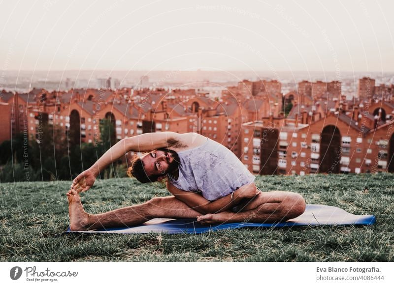 junger Mann in einem Park übt Yoga Sport. Stadt Hintergrund. gesunden Lebensstil. Großstadt Sonnenuntergang Lifestyle Gesundheit Unterlage Sportkleidung