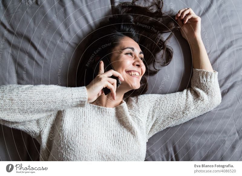 junge Frau, die am Telefon spricht und lächelt Kaffee Lifestyle lässig Internet Business Vernetzung Selfie sozial Bett Haus heimwärts Schlafzimmer Morgen