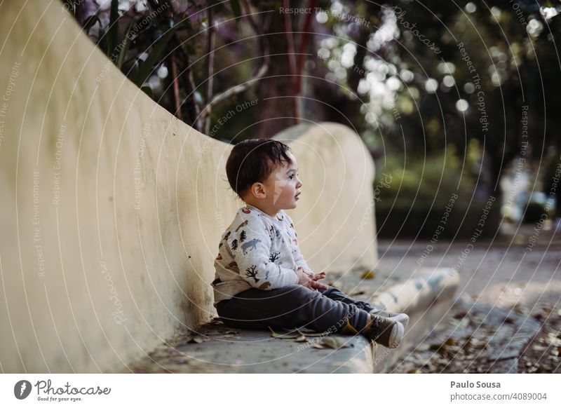 Junge sitzend im Park Kind 1-3 Jahre Kaukasier Sitzen niedlich Farbfoto Kindheit Kleinkind Mensch Lifestyle Außenaufnahme Tag Freude Kinderspiel authentisch