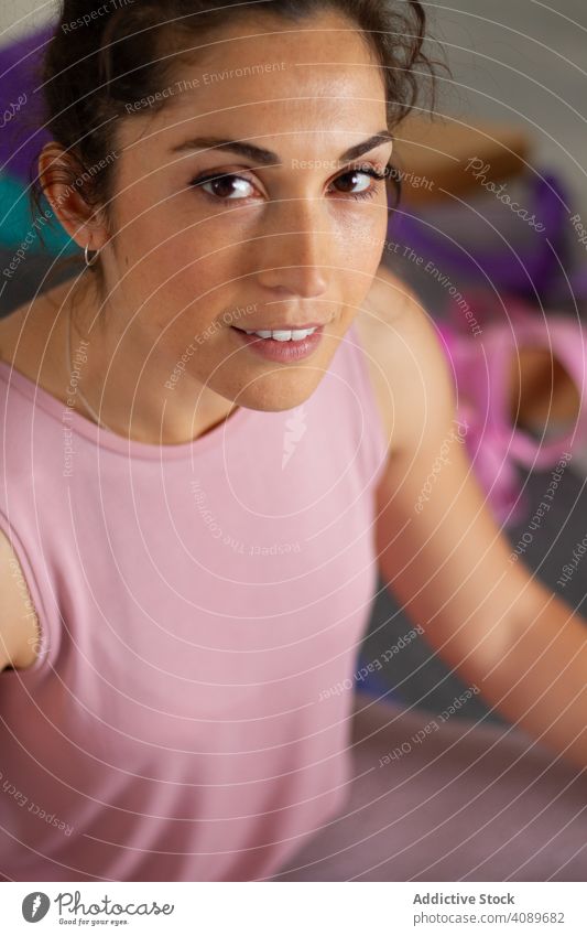 Frau in Sportkleidung ruht und schaut in die Kamera Yoga Pose Gerät sportlich jung attraktiv ernst beweglich Sitzen positionieren brünett Erholung Harmonie