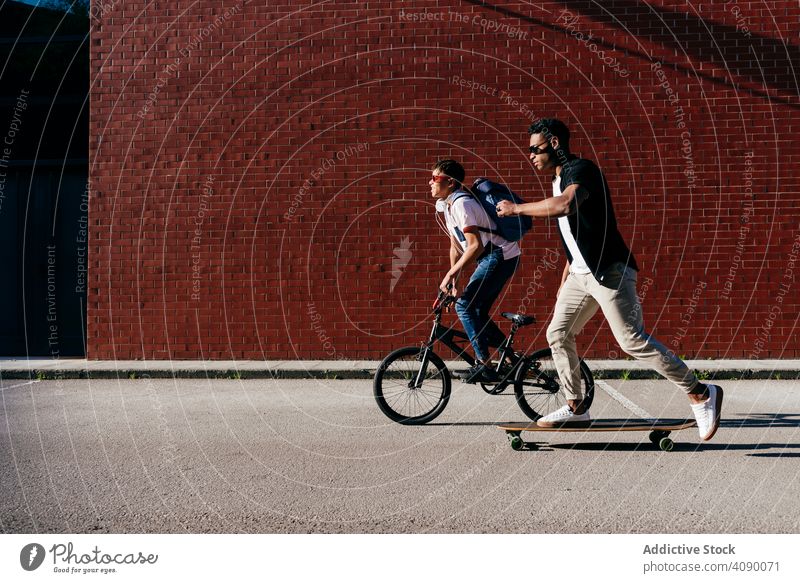 Junge afroamerikanische Männer fahren Fahrrad und Skateboard Reiten schwarz Sport Aktivität Lifestyle Freunde Hipster jung Afroamerikaner männlich ethnisch