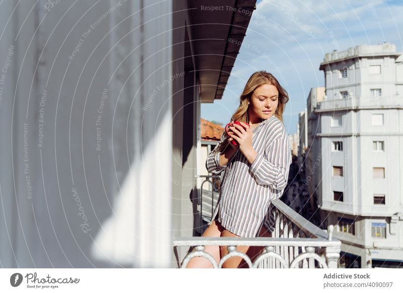 Junge sexy fröhliche Frau mit Tasse auf der Terrasse Balkon Glück Reling Lehnen jung Freude schön attraktiv hübsch charmant sinnlich cool verführerisch