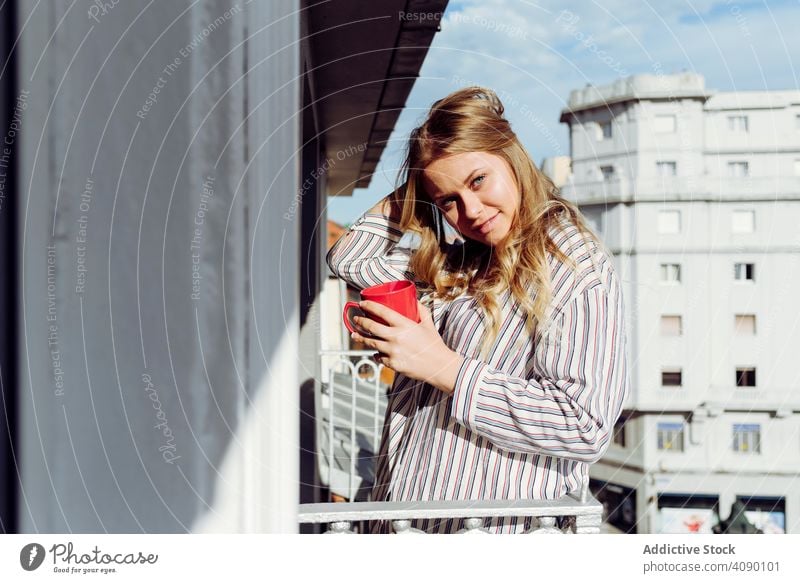 Junge sexy fröhliche Frau mit Tasse auf der Terrasse Balkon Glück Reling Lehnen jung Lächeln Freude heiter schön attraktiv hübsch charmant sinnlich cool