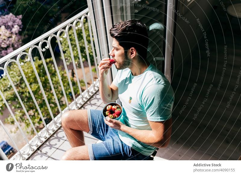 Junge glücklich sexy männlich essen Erdbeere in der Nähe von Terrasse Mann Essen Erdbeeren Schalen & Schüsseln Glück Unterwäsche Balkon jung Freude heiter