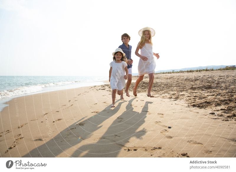 Kinder laufen am Meeresufer entlang rennen Strand Sommer Urlaub MEER Lifestyle Glück Zusammensein Fröhlichkeit Wasser Sand Menschen Freude Feiertag schön