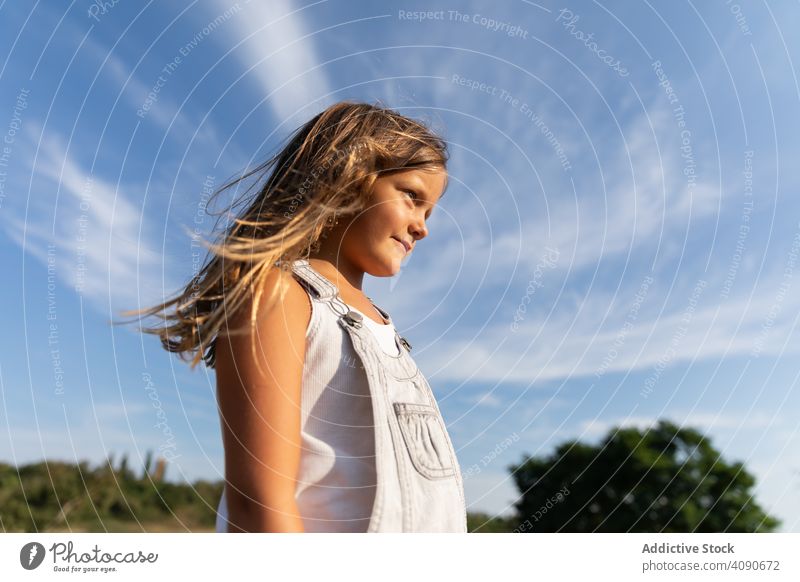 Junges Mädchen posiert im Sonnenlicht und schaut weg posierend selbstbewusst Sommer Natur stylisch nachdenklich Kind bezaubernd Ausdruck Urlaub unschuldig