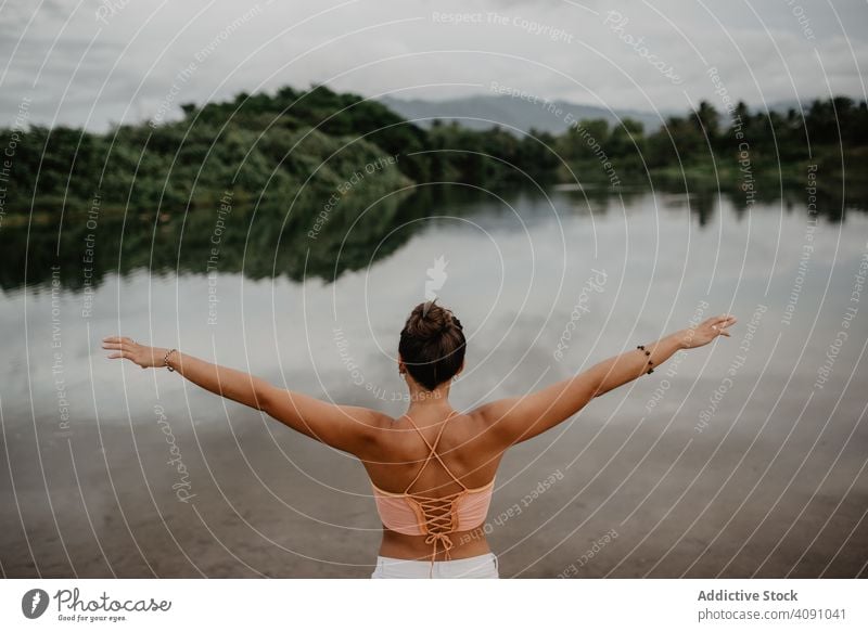 Unerkennbare Frau genießt die Freiheit am See ausgestreckte Arme jung Landschaft Freude Natur Lifestyle Freizeit gestikulieren Teich Windstille ruhig