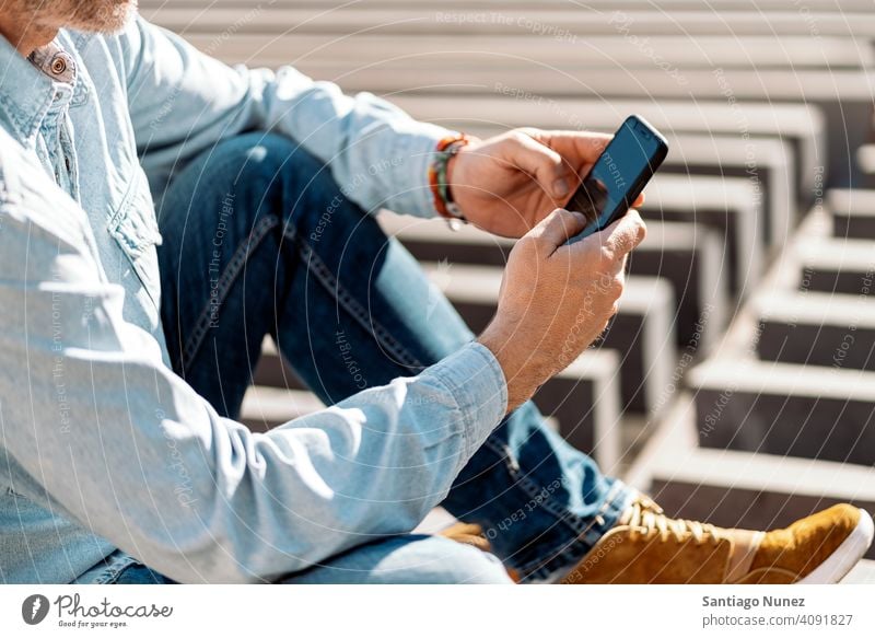 Nahaufnahme eines Geschäftsmannes, der sein Smartphone auf der Straße benutzt. Mann Person Lifestyle Menschen mittleres Alter gutaussehend Senior im Freien