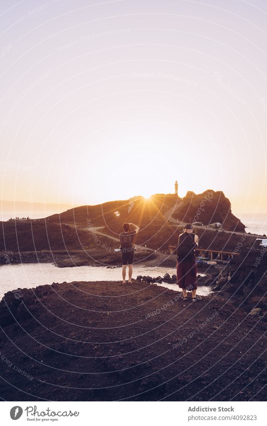 Reisende nehmen Foto am Meer bei Sonnenuntergang Reisender fotografierend Seeküste Fotografie Klippe Landschaft Fotografieren Fotokamera Tourist schön Urlaub