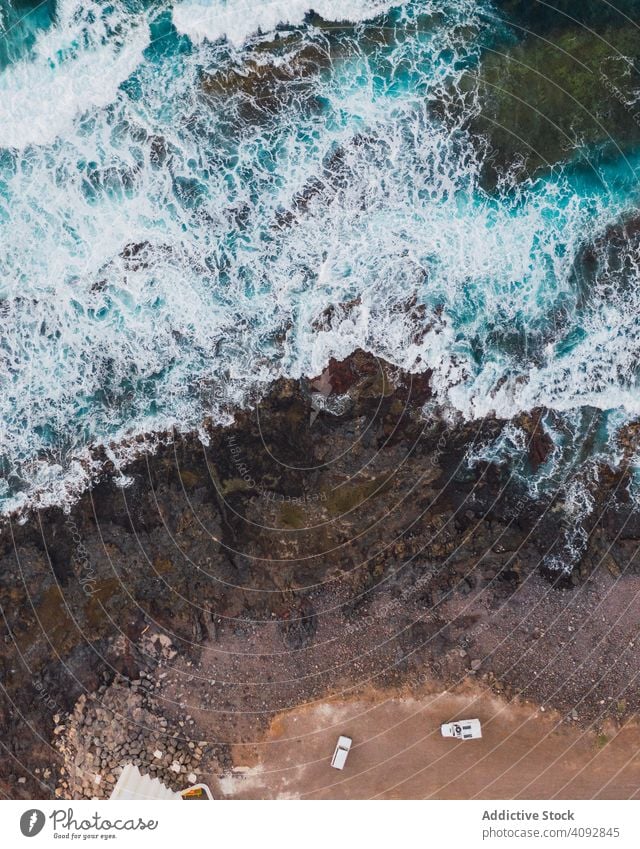 Drohnenansicht der Küste mit Klippen Küstenlinie Wellen felsig Geplätscher abgelegen Antenne schaumig Tageslicht Spanien Teneriffa Wasser Höhe Meer Landschaft