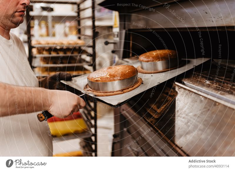 Kahlköpfiger Bäcker prüft Gebäck im Ofen Mann Bäckerei schauen Sie Arbeit Konditor prüfen Koch heiß Prozess männlich Erwachsener Uniform Küche Kleinunternehmen