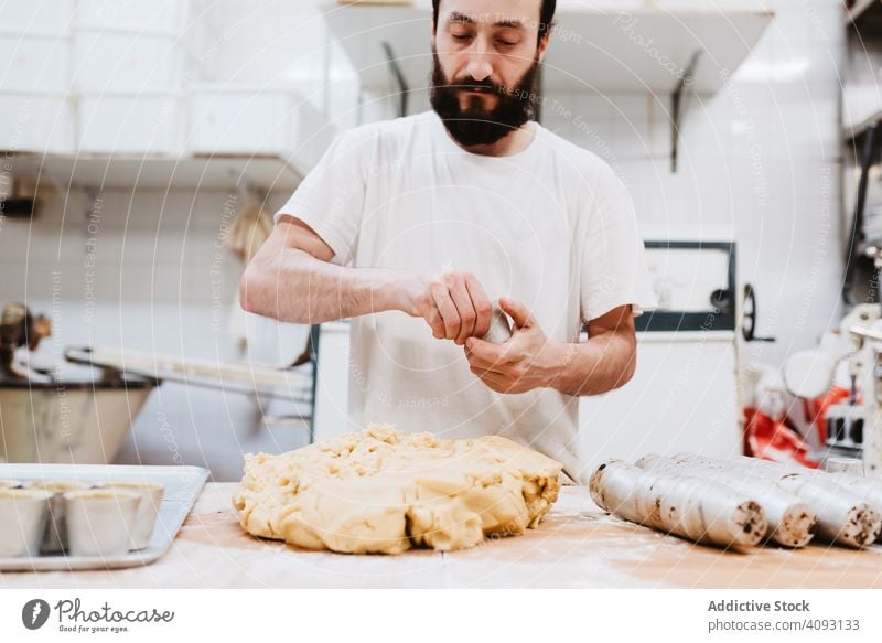 Nicht erkennbarer Koch legt Teig in Tasse Konditor Bäckerei Teigwaren setzen Tisch Küche Gebäck Vorbereitung frisch Mann roh professionell backen Lebensmittel