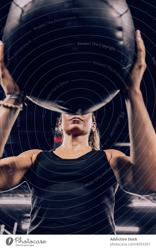 Muskulöse Frau trainiert mit Ball im Fitnessstudio Übung Fitball Training Fitness-Studio sportlich muskulös Sportbekleidung passen Gesundheit Körper aktiv