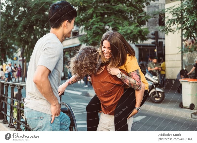 Unbeschwerte multirassische Freunde haben Spaß auf der Straße Spaß haben Huckepack spielerisch sorgenfrei Lachen stehen Großstadt Zusammensein Sommer vielfältig