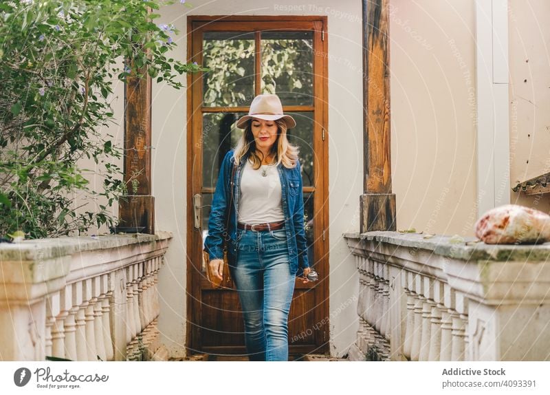 Frau geht auf alter Veranda Spaziergang Haus Lifestyle lassen Türöffnung Terrasse Architektur Außenseite trendy Lächeln hölzern Glas Inhalt schön Anschluss