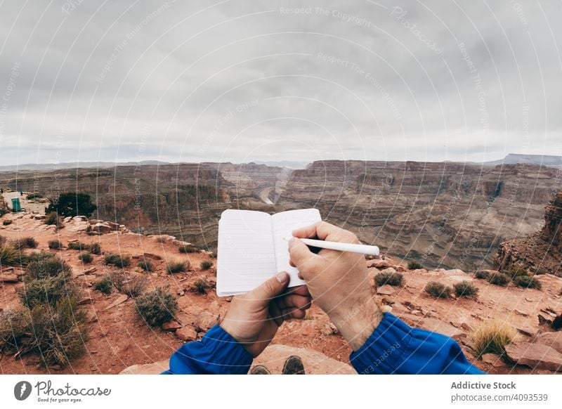 Männliche Zeichnung im Notizbuch am Felsen Mann Schlucht Klippe Saum Hinweis zeichnen Notebook Tagebuch ruhen männlich USA Natur reisen Landschaft Wanderer