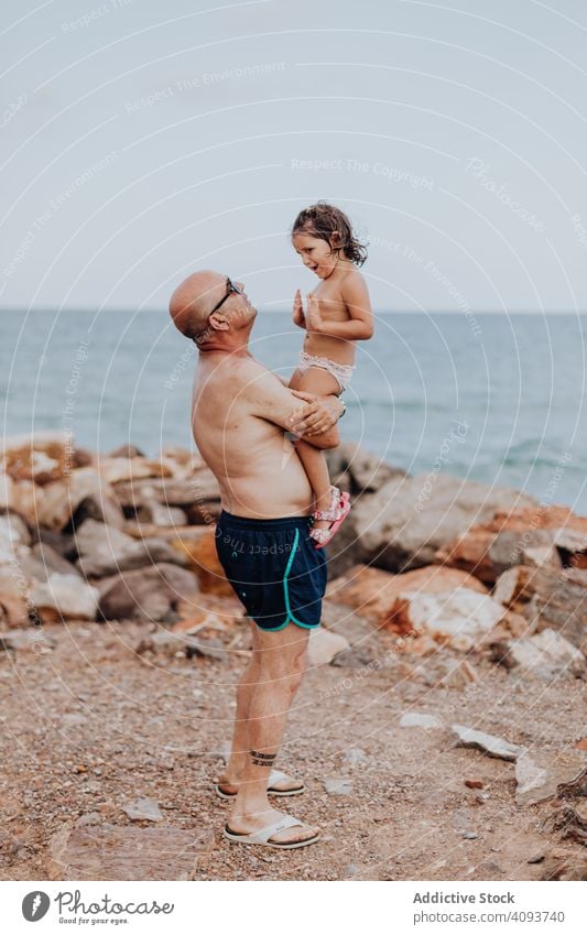 Grossvater und Enkelin amüsieren sich am felsigen Strand Urlaub Großvater Meer Familie älter Kind Mädchen Wasser Natur Ufer genießend in den Ruhestand getreten