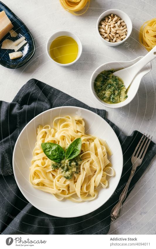 Servierter Teller mit Pesto-Nudeln neben einer Schüssel mit Sauce auf dem Tisch Spätzle Saucen Küche frisch gekocht weiß Knoblauch Erdöl Basilikum Tagliatelle